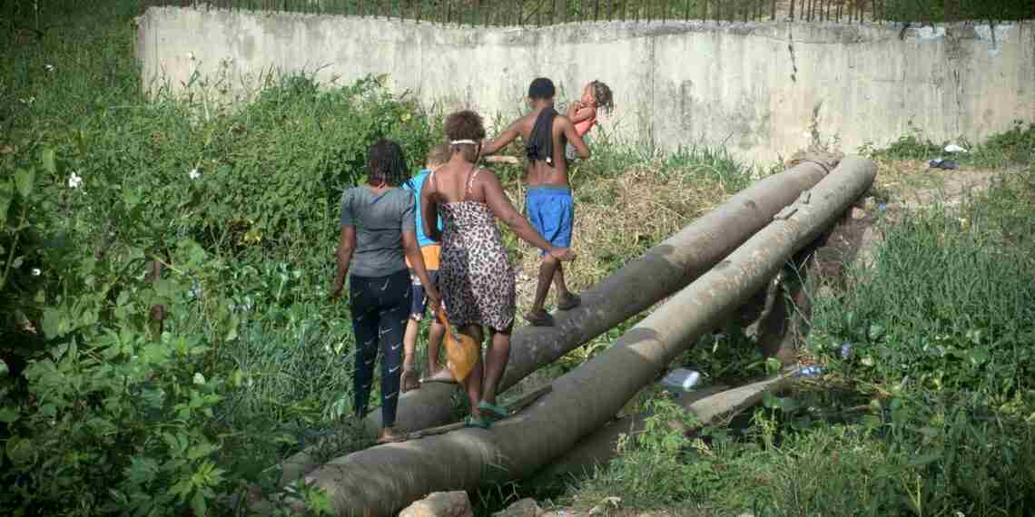 Cancino Adentro cruza sobre dos troncos mientras el puente prometido por Dio Astacio sigue sin llegar
